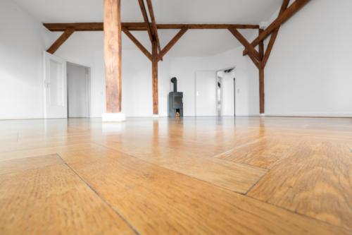 Parquet Floor Closeup In Emprty Penthouse Room With Fireplace